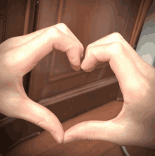 a person making a heart with their hands