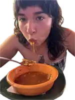 a woman with a tattoo on her chest is eating a bowl of soup with a spoon