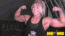 a woman flexes her muscles in a tank top that says keep on it