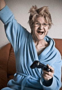 an elderly woman wearing a blue robe is playing a video game