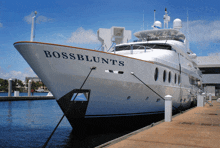 a white yacht named bossblunts is docked at a marina