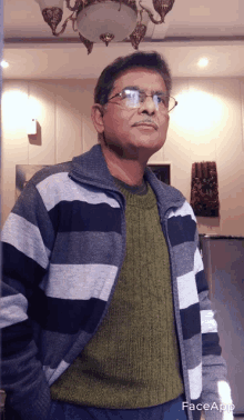 a man wearing glasses and a striped sweater has faceapp written on the bottom of his photo