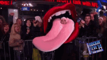 a woman in a pink tongue costume stands in front of a crowd of people at a rockin ' eve 14 event