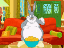 bugs bunny from looney tunes is sitting on a couch eating chips from a bowl .