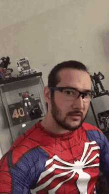 a man wearing a spiderman costume and glasses is standing in front of a display case that has a number 40 on it