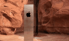 an apple logo is on a metal object in front of some rocks