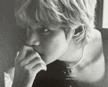 a black and white photo of a young man with a pearl necklace and earrings