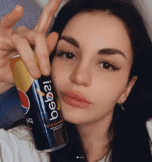 a woman is holding a can of pepsi in her hand