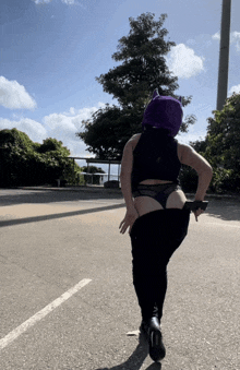 a woman wearing a purple cat hood is walking down the road