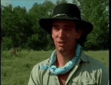 a man wearing a black hat and a blue bandana around his neck