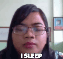 a woman wearing glasses says i sleep in a blurry photo .