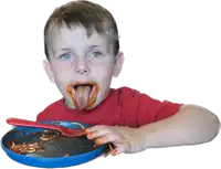 a young boy in a red shirt is eating from a blue plate with a red fork