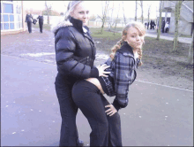 two girls are posing for a picture and one has her hand on the other 's waist