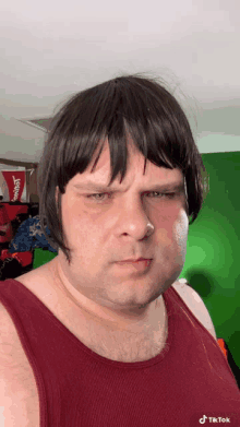 a man wearing a wig and a red tank top has a tiktok watermark