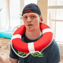 a man with a life preserver around his neck wearing a shirt that says underneath