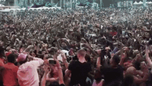 a crowd of people are gathered at a concert and taking pictures with their phones