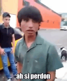 a young man in a green shirt is standing in front of a car with a dog .