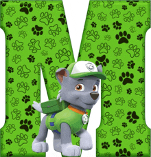 a green letter m with paw prints and rocky from paw patrol on it