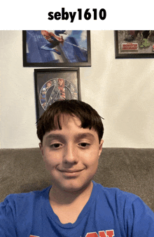 a boy wearing a blue shirt with the number 1610 on top