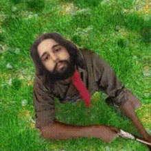 a man with long hair and a beard is laying on the grass