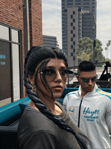 a man and woman wearing sunglasses and a jacket that says hayer on it