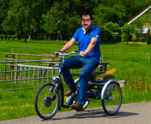 a man wearing glasses and a mustache rides a bicycle