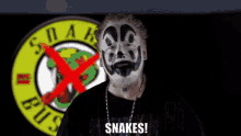 a man with paint on his face says snakes in front of a sign