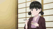 a girl in a kimono is holding a plate and chopsticks