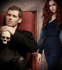 a man sitting in a chair holding a skull next to a woman in a black dress