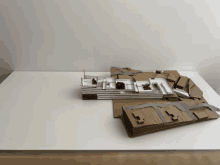 a model of a building sits on a white surface