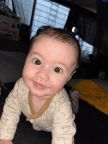 a baby is crawling on his stomach and looking at the camera with a box in the background that says husky