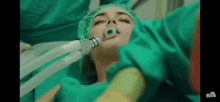 a woman in an operating room with an anesthesia mask on her face