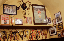 a picture of a man holding a soccer ball hangs on a wall along with many other pictures