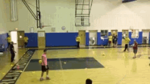 a group of children are playing soccer in a gym with a sign on the floor that says ' soccer '