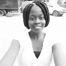 a black and white photo of a woman with braids in front of a truck