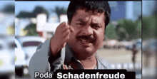 a man with a mustache is making a funny face with the words poda schadenfreude written above him