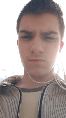 a young man wearing headphones and a striped jacket