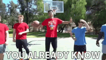 a group of young men are playing basketball on a court and one of them is holding a basketball in his hand .