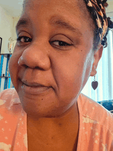 a close up of a woman 's face with a headband and earrings