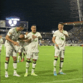 a group of soccer players standing on a field with one wearing a shirt that says ' ams ' on it