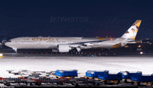 an etihad airplane sits on a runway at night