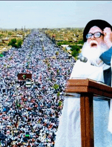 a man stands at a podium in front of a large crowd