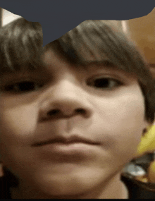 a close up of a young boy 's face with a blurred background