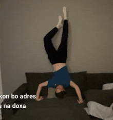 a man is doing a handstand on a couch with the words ken bo adres na doxa in the corner