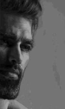 it is a black and white photo of a man with a beard .