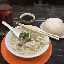 a bowl of soup next to a bottle of sala iced tea