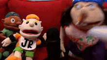 a puppet with a bib that says jr is standing next to another puppet