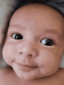 a close up of a baby 's face with a smile on his face