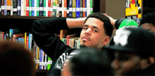 a man sitting in front of a bookshelf with a book titled ' a brief history of the world '