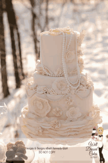 a wedding cake with pearls and ruffles is displayed on a table